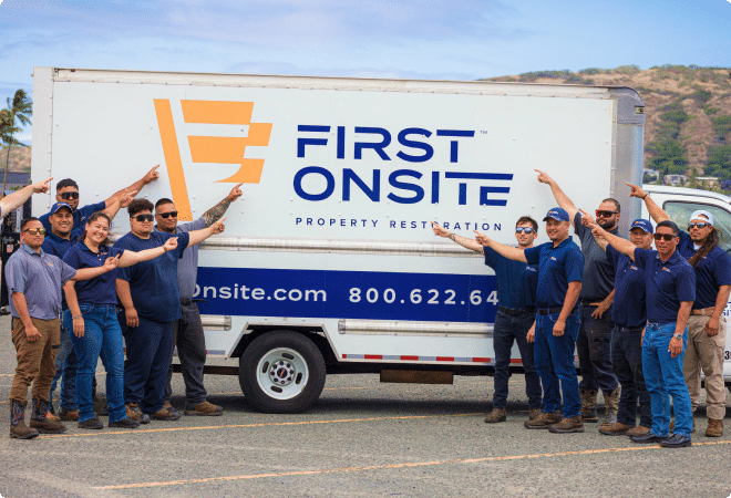 group of employees pointing to a first onsite truck