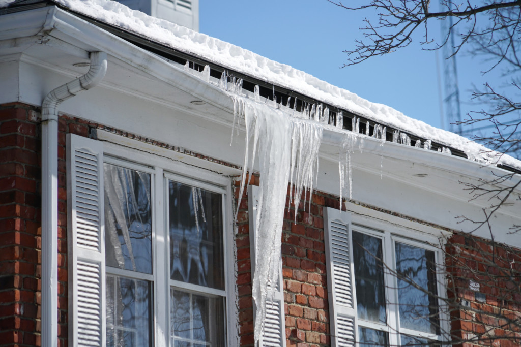 propiedad residencial con daños por capa de hielo en el sistema de canalones y en el techo
