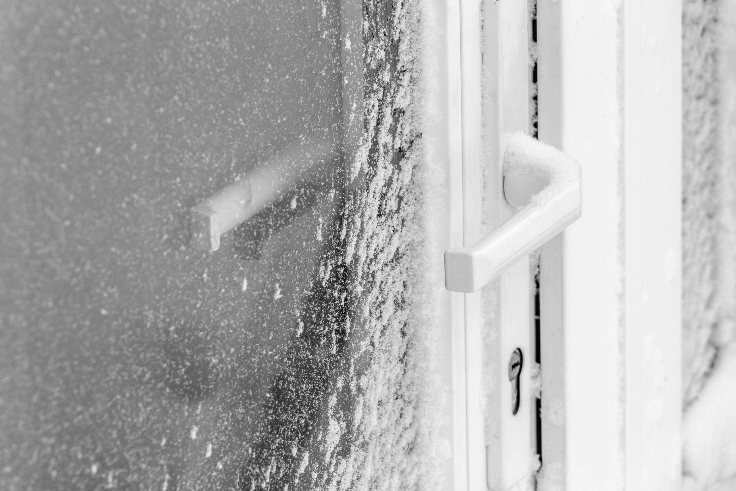 manilla de la puerta cubierta de nieve tras la tormenta de nieve