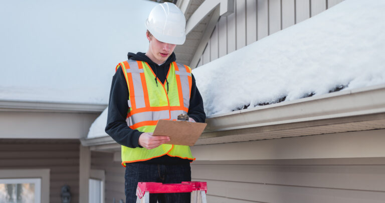 technicien inspectant un toit pour détecter la présence de neige